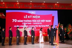 Thủ tướng Nguyễn Tấn Dũng gắn Huân chương Độc lập hạng Nhất lên Cờ truyền thống của Thông tấn xã Việt Nam. (Ảnh: TTXVN)
