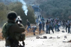 Binh sỹ Israel bắn đạn hơi cay vào người biểu tình Palestine ở khu Bờ Tây. (Ảnh: AFP/TTXVN)