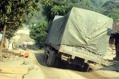 Chiếc xe tải bị xa vào ổ voi trên đường. (Ảnh: Quôc Đạt/TTXVN)