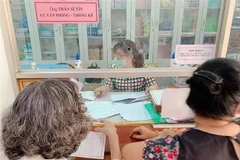 Cán bộ phường 5, quận 3 chi trả hỗ trợ tại phường cho các trường hợp gặp khó khăn do đại dịch COVID-19 theo Nghị quyết 42 của Chính phủ. (Ảnh: TTXVN)