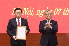 Thường trực Ban Bí thư Trần Quốc Vượng trao quyết định bổ nhiệm đồng chí Vương Đình Huệ làm Bí thư Thành ủy Hà Nội.(Ảnh: Văn Điệp/TTXVN)