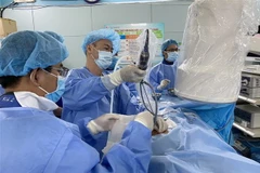 Bác sỹ Bệnh viện Bình Dân phẫu thuật nội soi qua da lấy sỏi thận cho bệnh nhi 3 tuổi. (Ảnh: TTXVN)