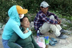 Người nhà các nạn nhân đau buồn chờ tin người thân trên bờ sông. (Ảnh: Trịnh Bang Nhiệm/TTXVN)