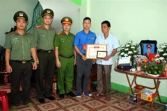 Bí thư Tỉnh đoàn, Chủ tịch Hội Liên hiệp Thanh niên tỉnh Bắc Giang Thân Trung Kiên truy tặng huy hiệu 'Tuổi trẻ dũng cảm' của Trung ương Đoàn cho chiến sỹ công an nghĩa vụ Nguyễn Văn Mạnh hy sinh khi làm nhiệm vụ. (Ảnh: Đồng Thúy/TTXVN)