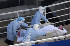 Nhân viên y tế chuyển bệnh nhân nhiễm virus corona chủng mới tới điều trị tại bệnh viện dã chiến Hỏa Thần Sơn ở Vũ Hán, tỉnh Hồ Bắc, Trung Quốc, ngày 4/2/2020. (Ảnh: THX/TTXVN)