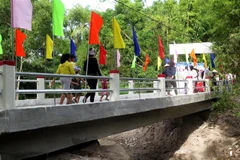 Người dân phấn khởi khi được đi trên cây cầu mới khang trang. (Ảnh: Phước Ngọc/TTXVN)