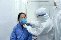 Bác sỹ Đội cơ động Bệnh viện Bạch Mai (Hà Nội) thăm khám cho bệnh nhân dương tính với virus corona chủng mới tại Trung tâm y tế huyện Bình Xuyên, Vĩnh Phúc. (Ảnh: Hoàng Hùng/TTXVN)