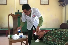 Lực lượng quân y chăm sóc các thuyền viên ngay sau khi được đưa lên bờ. (Ảnh: TTXVN)