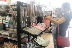 Người tiêu dùng mua sắm sản phẩm may mặc tại Trung tâm thương mại Akuruhi Tower trong ngày khai trương. (Ảnh: Mỹ Phương/TTXVN)