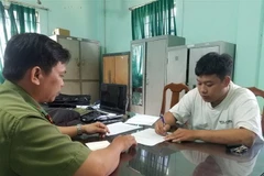 Công an làm việc với Trần Văn Tùng. (Ảnh: TTXVN)