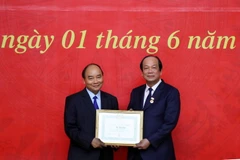 Ủy viên Bộ Chính trị, Bí thư Ban Cán sự Đảng Chính phủ, Thủ tướng Chính phủ Nguyễn Xuân Phúc trao huy hiệu 40 năm tuổi Đảng cho ông Mai Tiến Dũng, Ủy viên Ban chấp hành Trung ương Đảng, Bí thư Đảng ủy, Bộ trưởng Chủ nhiệm Văn phòng Chính phủ. (Ảnh: Thống