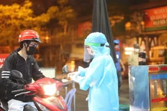 Nhân viên y tế kiểm tra và sát khuẩn cho những người vào bênh viện. (Ảnh: Dương Giang/TTXVN)