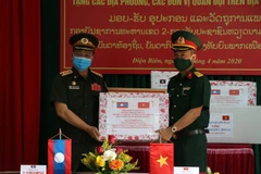 Đại diện lãnh đạo Trung đoàn 82 (Quân khu 2) tặng đơn vị kết nghĩa Sư đoàn Bộ binh 3 Quân đội nhân dân Lào một số vật tư, trang thiết bị y tế phòng chống dịch COVID-19. (Ảnh: Phan Tuấn Anh/TTXVN)