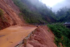 Lực lượng chức năng khẩn trương xử lý san gạt bùn đất trên Quốc lộ 12 Phong Thổ đi Nậm Nhùn, Mường Tè. (Ảnh: Quý Trung/TTXVN)