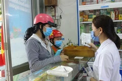 Nhân viên nhà thuốc tặng khẩu trang y tế cho người dân, chiều 31/1. (Ảnh: Phan Sáu/TTXVN)