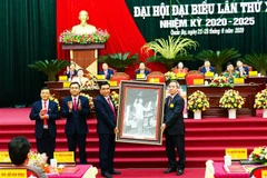 Ủy viên Bộ Chính trị, Bí thư Trung ương Đảng, Trưởng Ban Kinh tế Trung ương Nguyễn Văn Bình trao tặng bức ảnh Chủ tịch Hồ Chí Minh cho Đại hội. (Ảnh: Minh Tâm/TTXVN)