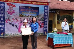 Lãnh đạo Tỉnh đoàn Bình Phước trao bằng khen cho em Thái Đình Nhân. (Ảnh: Đậu Tất Thành/TTXVN)