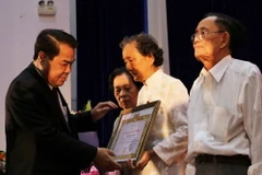 Bí thư Tỉnh ủy Cà Mau Dương Thanh Bình trao Huy hiệu Đảng cho đảng viên cao niên. (Ảnh: Thế Anh/TTXVN)