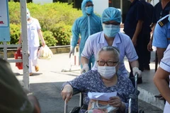 Y bác sỹ Bệnh viện C Đà Nẵng dìu bệnh nhân ra cổng để trở về nhà sau thời gian điều trị trong tình trạng bệnh viện bị cách ly. (Ảnh: Văn Dũng/TTXVN)