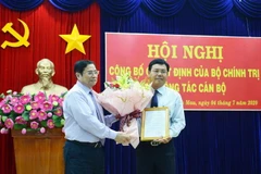 Trưởng ban Tổ chức Trung ương Phạm Minh Chính (trái) trao Quyết định của Bộ Chính trị chuẩn y ông Nguyễn Tiến Hải, Phó Bí thư Tỉnh ủy, Chủ tịch UBND tỉnh Cà Mau giữ chức Bí thư Tỉnh ủy Cà Mau, nhiệm kỳ 2015-2020. (Ảnh: Huỳnh Thế Anh/TTXVN)