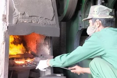 Dù thời tiết nắng nóng, hàng trăm con người ở làng rèn Tiến Lộc (Thanh Hóa) vẫn lao động, kiếm kế sinh nhai bên những chiếc lò lửa đỏ rực. (Ảnh: Khiếu Tư/TTXVN)