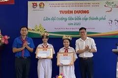 Lãnh đạo Thành đoàn trao vòng nguyệt quế tuyên dương Liên đội trưởng các trường ở quận 9 và Thủ Đức. (Ảnh: Thanh Vũ/TTXVN)