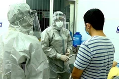 Nhân viên y tế thực hiện các biện pháp nghiệp vụ với bệnh nhân nghi mắc nCoV. (Ảnh: Thành Chung/TTXVN)