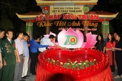 Các đại biểu thực hiện nghi lễ 'Thắp nến tri ân.' (Ảnh: Phan Quân/TTXVN)