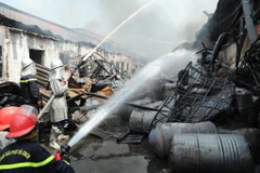 Lực lượng chức năng tiếp cận hiện trường, tích cực chữa cháy. (Ảnh: Nhật Anh/TTXVN)