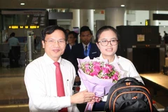  Cục trưởng Cục Quản lý chất lượng (Bộ Giáo dục và Đào tạo) Mai Văn Trinh đón, tặng hoa chúc mừng Nguyễn Khánh Linh - thành viên đoàn thi Olympic Vật lý quốc tế. (Ảnh: Thanh Tùng/TTXVN)