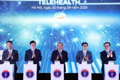 Thủ tướng Nguyễn Xuân Phúc và các đại biểu thực hiện nghi thức khánh thành kết nối 1000 cơ sở khám, chữa bệnh từ xa. (Ảnh: Thống Nhất/TTXVN)