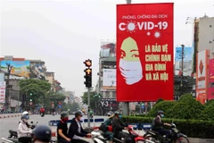Tranh cổ động tuyên truyền về COVID-19 được đặt ở các điểm nút giao thông của Hà Nội. (Ảnh: Thanh Tùng/TTXVN)