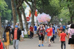 Người dân cần đeo khẩu trang nơi công cộng, khi tham gia giao thông.(Nguồn: TTXVN)