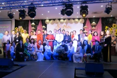 Đoàn nghệ thuật chụp hình lưu niệm với Ban tổ chức đêm hội. (Ảnh: Hoàng Linh/Vietnam+)