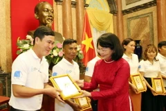 Phó Chủ tịch nước Đặng Thị Ngọc Thịnh tặng ảnh chân dung Chủ tịch Hồ Chí Minh cho các gia đình tiêu biểu năm 2020. (Ảnh: Dương Giang/TTXVN)