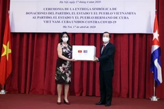 Bộ trưởng Bộ Xây dựng Phạm Hồng Hà, Thường trực Phân ban Việt Nam trong Ủy ban Liên Chính phủ hai nước trao tượng trưng 5.000 tấn gạo cho Đại sứ Cuba tại Việt Nam Lianys Torres. (Ảnh: Danh Lam/TTXVN)
