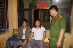 Hai đối tượng Nguyễn Chương Đại và Hoàng Văn Thám tại cơ quan điều tra. (Ảnh: Vũ Hà/TTXVN)