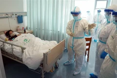 Nhân viên y tế kiểm tra tình trạng bệnh nhân nhiễm COVID-19 đang được điều trị tại một bệnh viện ở Vũ Hán, Trung Quốc ngày 18/2/2020. (Ảnh: THX/TTXVN)