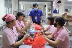 Phó Bí thư tỉnh Đoàn Vĩnh Phúc Nguyễn Trung Kiên thăm hỏi, tặng quà công nhân tại công ty Vina Korea. (Ảnh: Nguyễn Thảo/TTXVN)