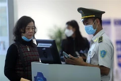 Hành khách chỉ phải bỏ khẩu trang để nhân viên an ninh hàng không đối chiếu giấy tờ tùy thân khi vào khu vực chờ lên máy bay. (Ảnh: Huy Hùng/TTXVN)