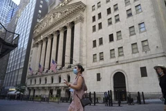 Người dân Mỹ đeo khẩu trang phòng chống COVID-19 khi đi bên ngoài Sàn giao dịch chứng khoán New York. (Ảnh: THX/TTXVN)