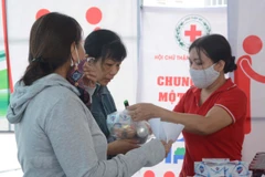 Người dân được phát miễn phí một số nhu yếu phẩm tại Chợ Nhân đạo. (Ảnh: Văn Dũng/TTXVN)