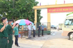 Các chiến sỹ cơ sở cách ly số 1 Trung đoàn Bộ binh 126 (thuộc Bộ Chỉ huy Quân sự tỉnh Hưng Yên) chào tạm biệt các công dân hoàn thành thời gian cách ly. (Ảnh: Đinh Tuấn/TTXVN)