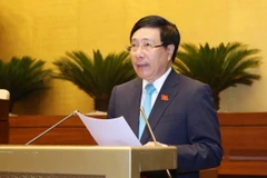 Phó Thủ tướng Chính phủ, Bộ trưởng Bộ Ngoại giao Phạm Bình Minh trình bày Tờ trình về dự án Luật Thỏa thuận quốc tế. (Ảnh: Phương Hoa/TTXVN)