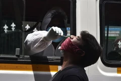 Nhân viên y tế lấy mẫu dịch xét nghiệm COVID-19 cho người dân tại Hyderabad, Ấn Độ. (Ảnh: THX/ TTXVN)