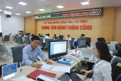 Cán bộ Trung tâm hành chính công tỉnh Hà Tĩnh giải quyết thủ tục hành chính cho người dân. (Ảnh minh họa: Hoàng Ngà/TTXVN)