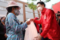 Ông Đào Ngọc Triệu, Chủ tịch Hội Chữ thập đỏ thành phố Hà Nội phát lương thực miễn phí cho người nghèo, người có hoàn cảnh khó khăn tại Trường THCS Đại Kim, phường Đại Kim, quận Hoàng Mai. (Ảnh: Thanh Tùng/TTXVN)