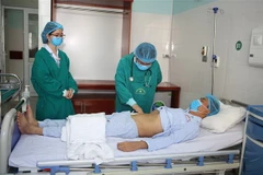 Bác sỹ Bệnh viện Đa khoa tỉnh Thanh Hóa thăm khám cho bệnh nhân L.V.T., 40 tuổi, bệnh nhân vừa được ghép thận từ người không cùng huyết thống. (Ảnh: Hoa Mai/TTXVN)