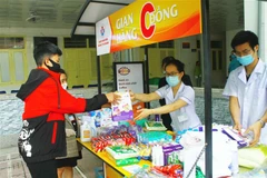 Bệnh nhân và người nhà bệnh nhân đến gian hàng 0 đồng tại Bệnh viện Sản nhi Nghệ An. (Ảnh: Tá Chuyên/TTXVN)