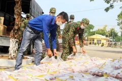 Đoàn viên thanh niên chuyển các phần quà đến trung tâm cách ly. (Ảnh: TTXVN)